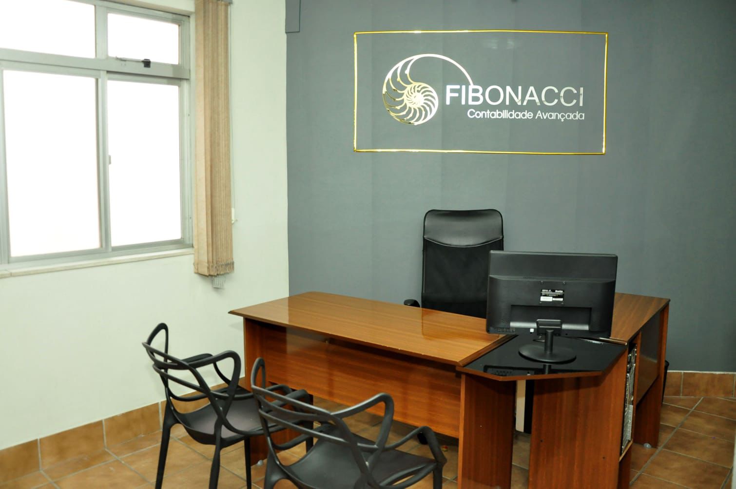 Sala de reunião da Fibonacci com mesa de atendimento e logo institucional